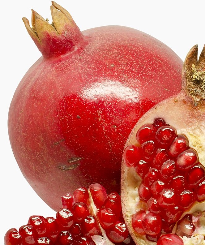 Whole pomegranate and a half-cut pomegranate with exposed seeds on a white background.