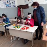 Children crocheting with their teacher